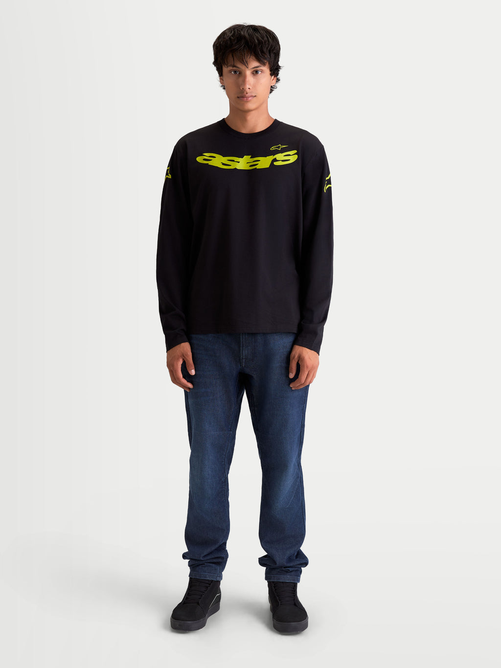 Alpinestars Velocifier CSF Langarm-T-Shirt, Motorsport-Sportswear für Herren, Schwarz und Gelb, mit gebogener Astars-Grafik auf der Brust, Schulterlogos und Rippbündchen, am Model dargestellt.