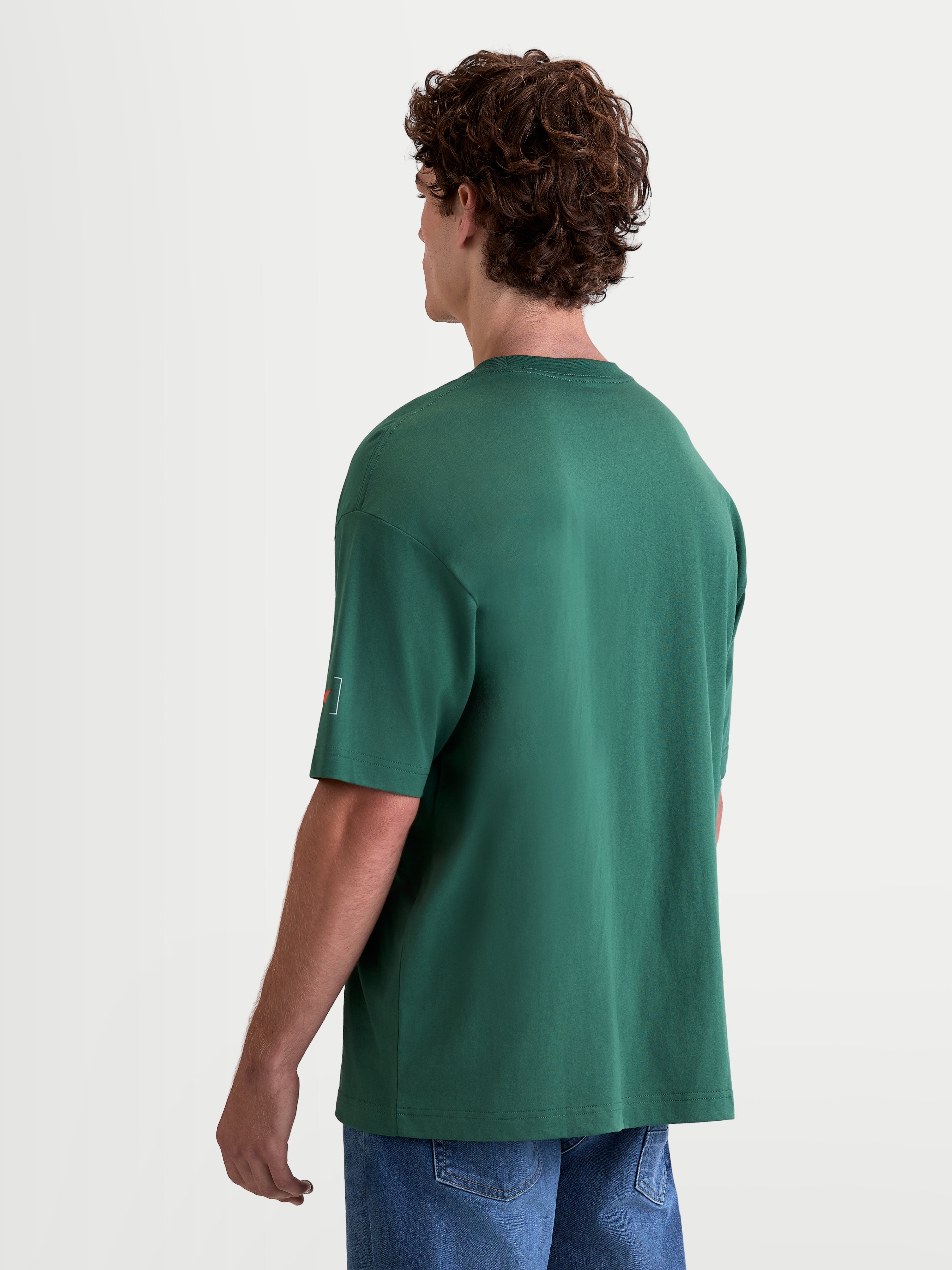 Alpinestars Infinity Oversized CSF T-Shirt, Herren-Kurzarm-Sport-T-Shirt, Grün, Oversized-Passform, Rückansicht am Modell mit Astars-Logo am Ärmel, Baumwoll-Polyester-Mischung.