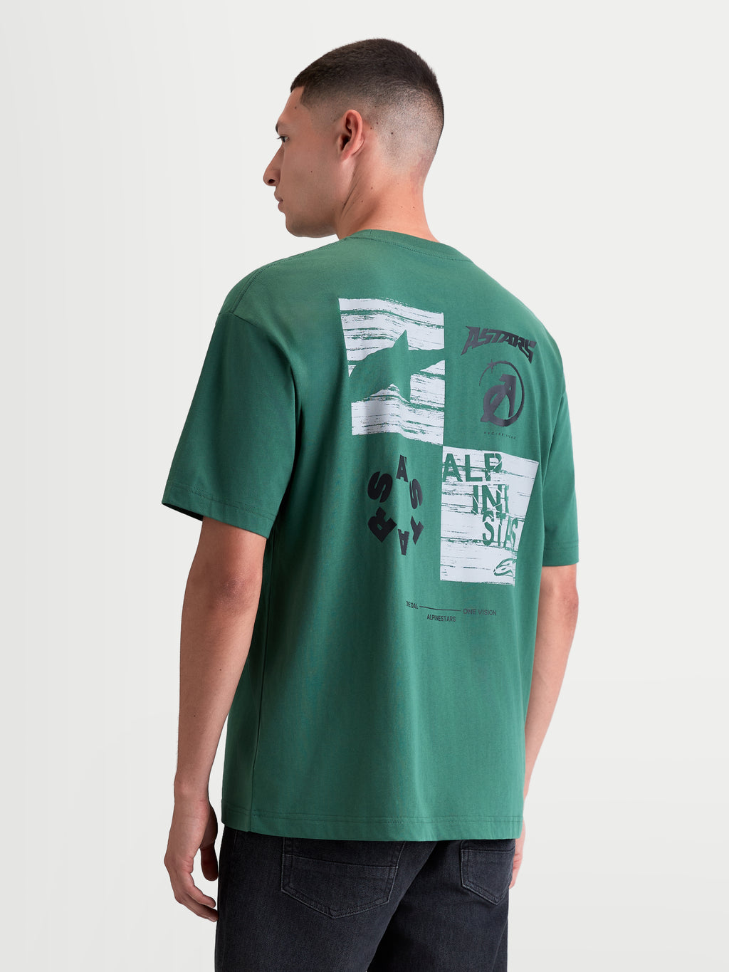 Alpinestars Checkback Oversized CSF T-Shirt, Kurzarm-Sportswear-T-Shirt für Herren und Damen, Rückansicht am Model mit markanter weiß-schwarzer Schachbrettgrafik, Astars-Logo und Motorsport-Branding, Farbe Grün, lässige Oversized-Passform.