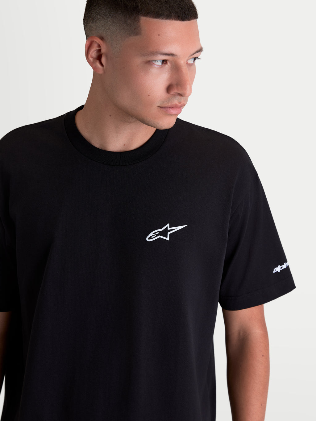 Alpinestars Mandate Oversized CSF T-Shirt, Kurzarm-Sportswear für Herren, Schwarz mit weißem Astars-Logo im Puff-Druck auf der Brust, entspannte Oversized-Passform, Grafik am Ärmel, Baumwoll-Polyester-Mischung.