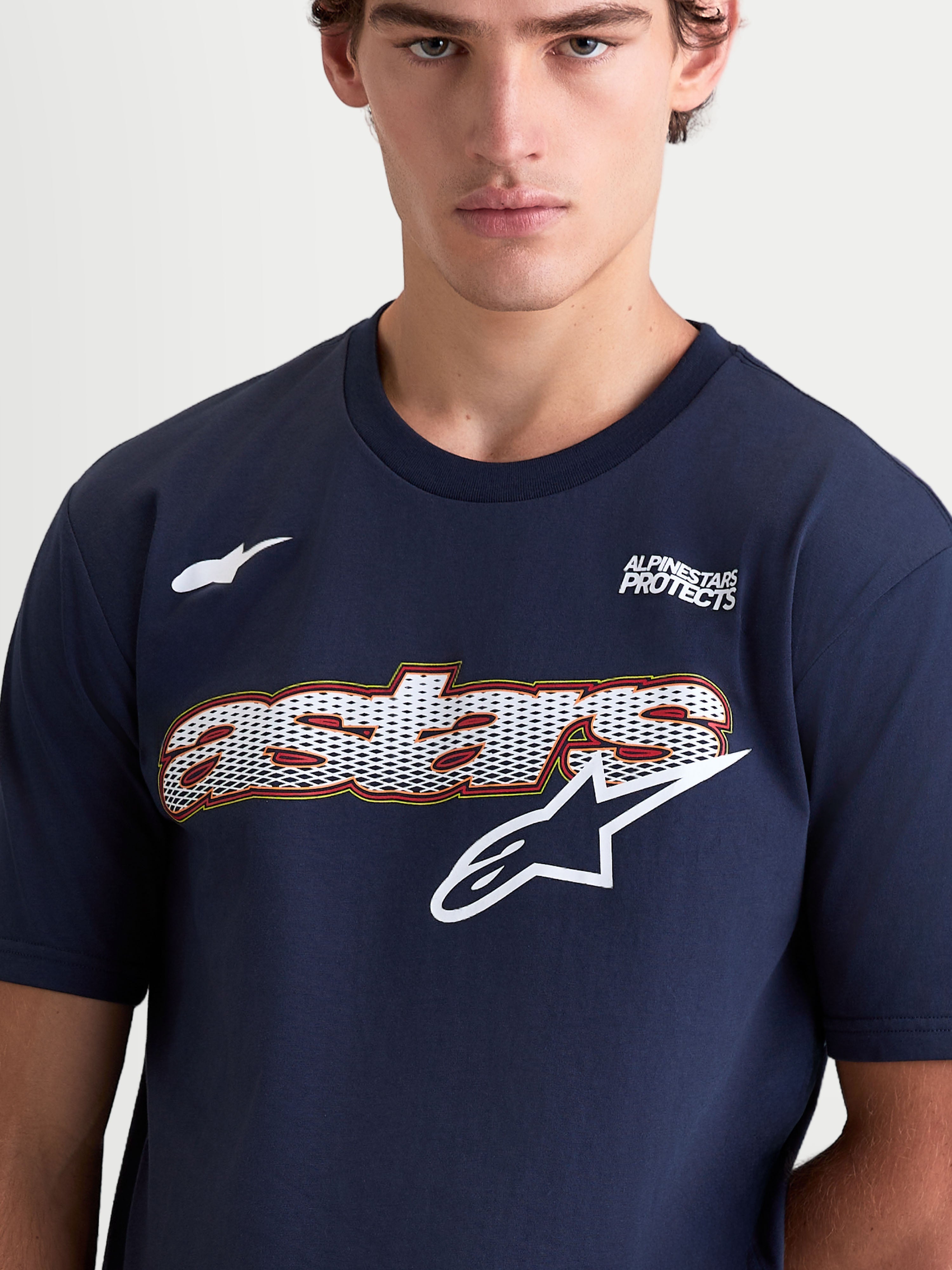 Alpinestars Cypress CSF T-Shirt, Herren-Kurzarm-Sportswear-T-Shirt, Blau und Weiß, mit Mesh-Fill-Astars-Wortgrafik und Logo auf der Brust, Alpinestars Protects-Schriftzug, Baumwoll-Polyester-Mischung, Nahaufnahme am Model.