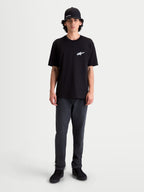 Alpinestars Meteor CSF T-Shirt, Kurzarm-Sportswear-T-Shirt, Schwarz mit weißem Astars-Logo auf der Brust, bequeme Baumwoll-Polyester-Mischung, lässiger Motorsport-Look am Model.