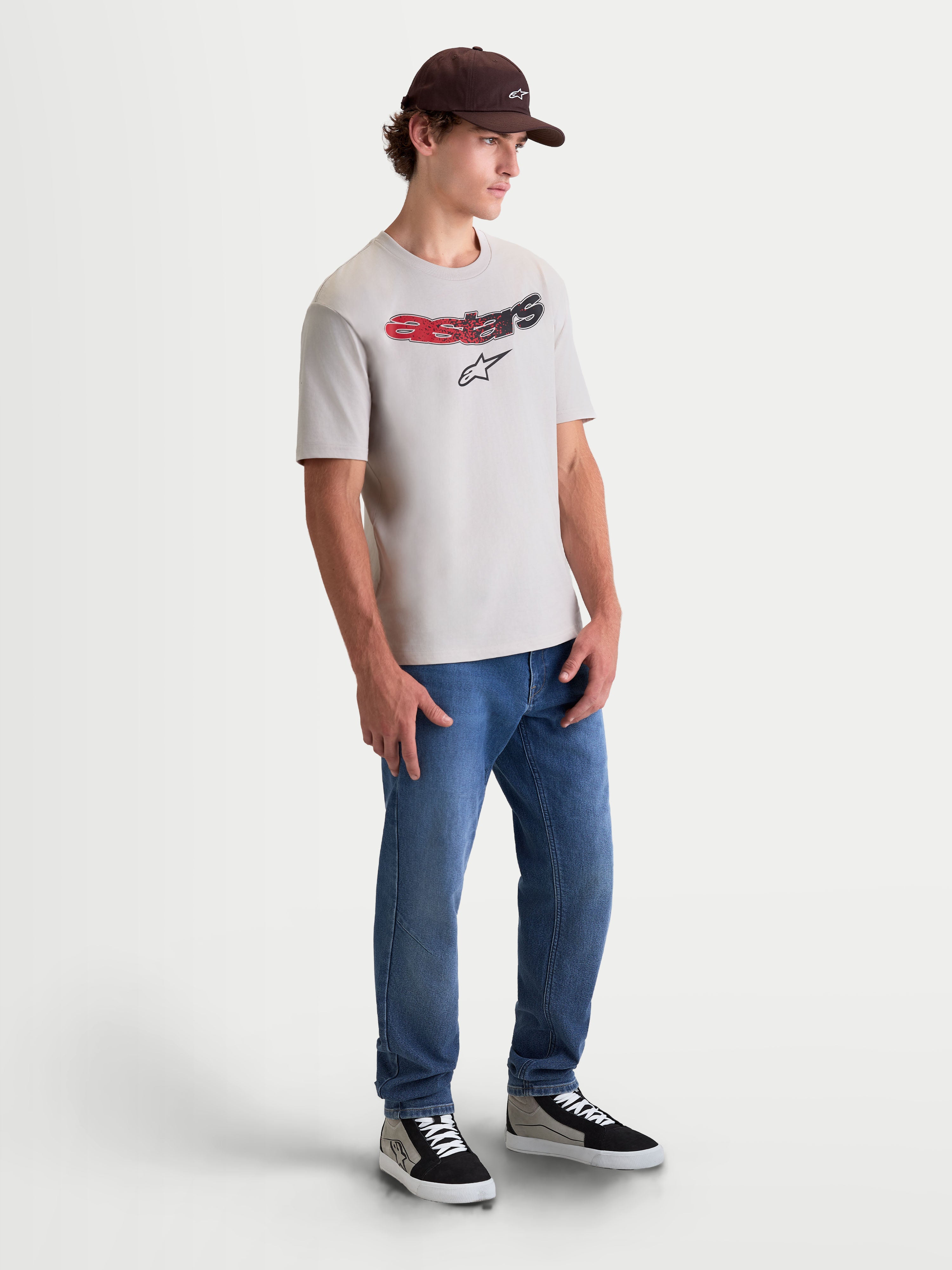 Alpinestars Elliptogrit CSF T-Shirt, Kurzarm-Sportswear-T-Shirt, Grau, mit gebogenem Astars-Schriftzug, rotem und schwarzem Farbverlauf und Soft-Hand-Print, On-Model-Ganzkörperaufnahme für einen lässigen Motorsport-Lifestyle-Look.
