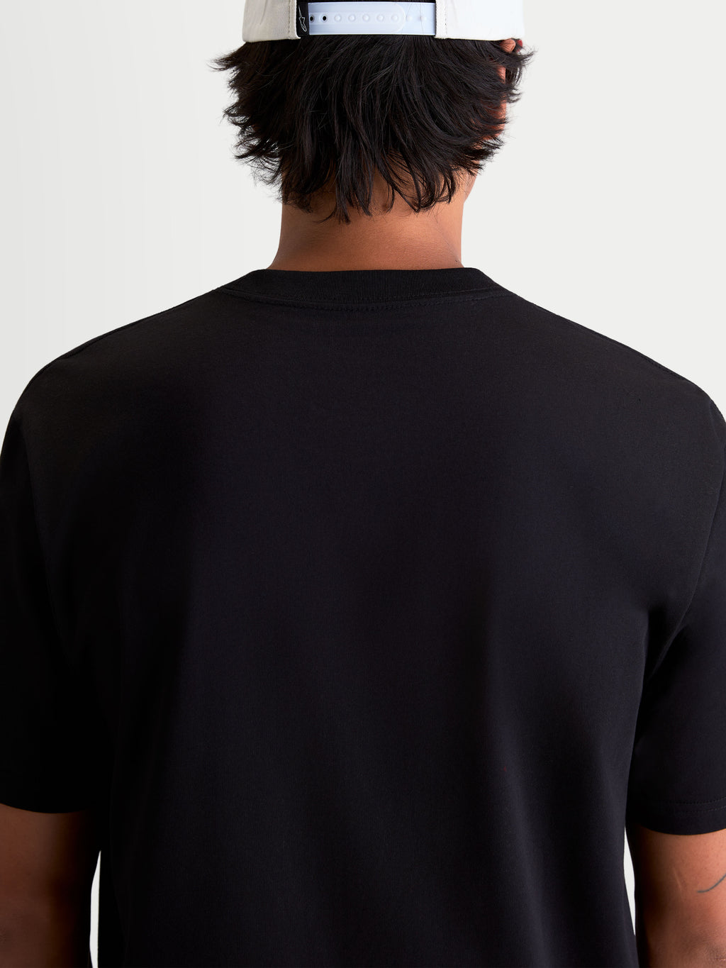 Alpinestars P1 CSF T-Shirt, Kurzarm-Sportswear-T-Shirt in Schwarz, Rückansicht am Model, bequemer 60/40 Baumwoll-Polyester-Mix, lässige Motorsport-Bekleidung.