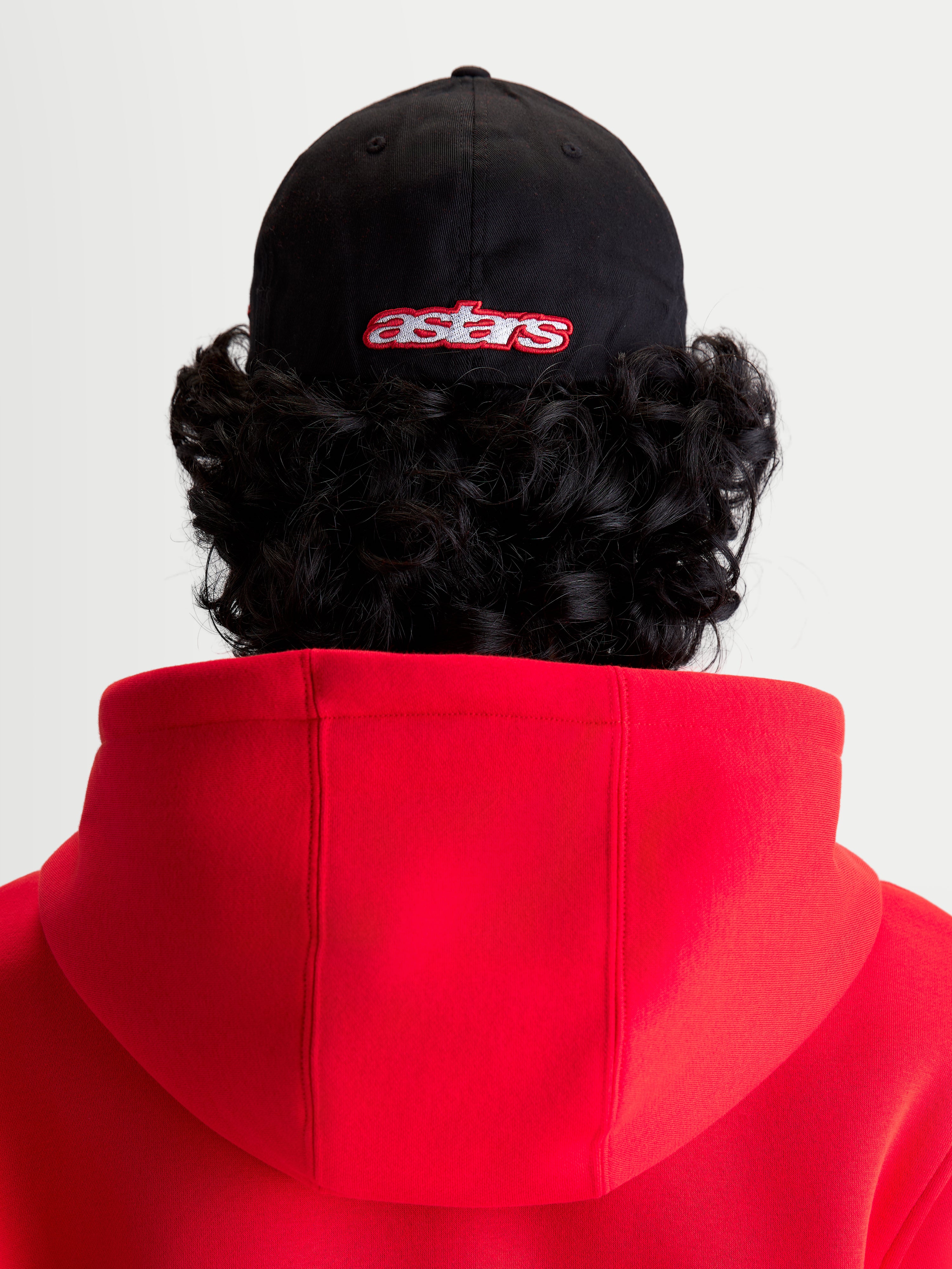 Alpinestars Lineout Kappe, Sportswear-Baseballkappe in Schwarz und Rot, Rückansicht am Modell mit besticktem Astars-Logo, strukturierte Krone, Twill-Gewebe-Konstruktion.