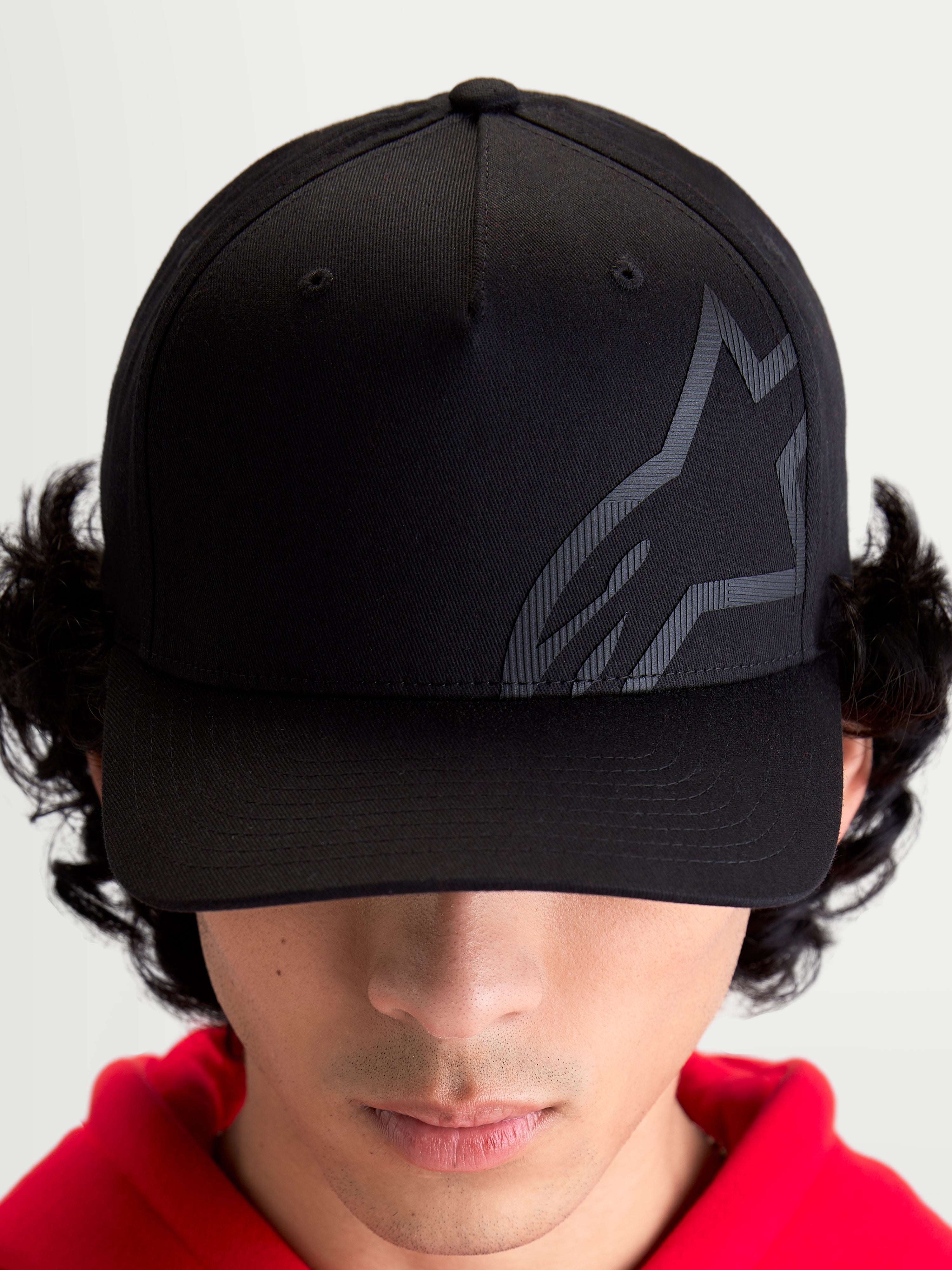 Alpinestars Maze Kappe, Motorsport-inspirierte Sportswear-Baseballkappe, Unisex, Schwarz, Twill-Gewebe mit strukturierter Krone, gebogenem Schirm und strukturiertem tonalem Astars Corp Shift Logo, Frontansicht am Model.