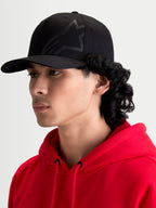 Alpinestars Maze Kappe, schwarze vom Motorsport inspirierte Sportswear-Kappe für Herren, mit strukturierter Krone, gebogenem Schirm und strukturiertem Astars Corp Shift Logo, Seitenprofil-Ansicht am Modell.