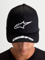 Alpinestars Arclight Kappe, schwarze Sportswear-Baseball-Kappe, Vorderansicht am Modell mit weißem Astars-Logo im Puff-Druck auf der strukturierten Krone und gebogenem Schriftzug auf dem Schirm, motorsport-inspirierte Freizeitkleidung.
