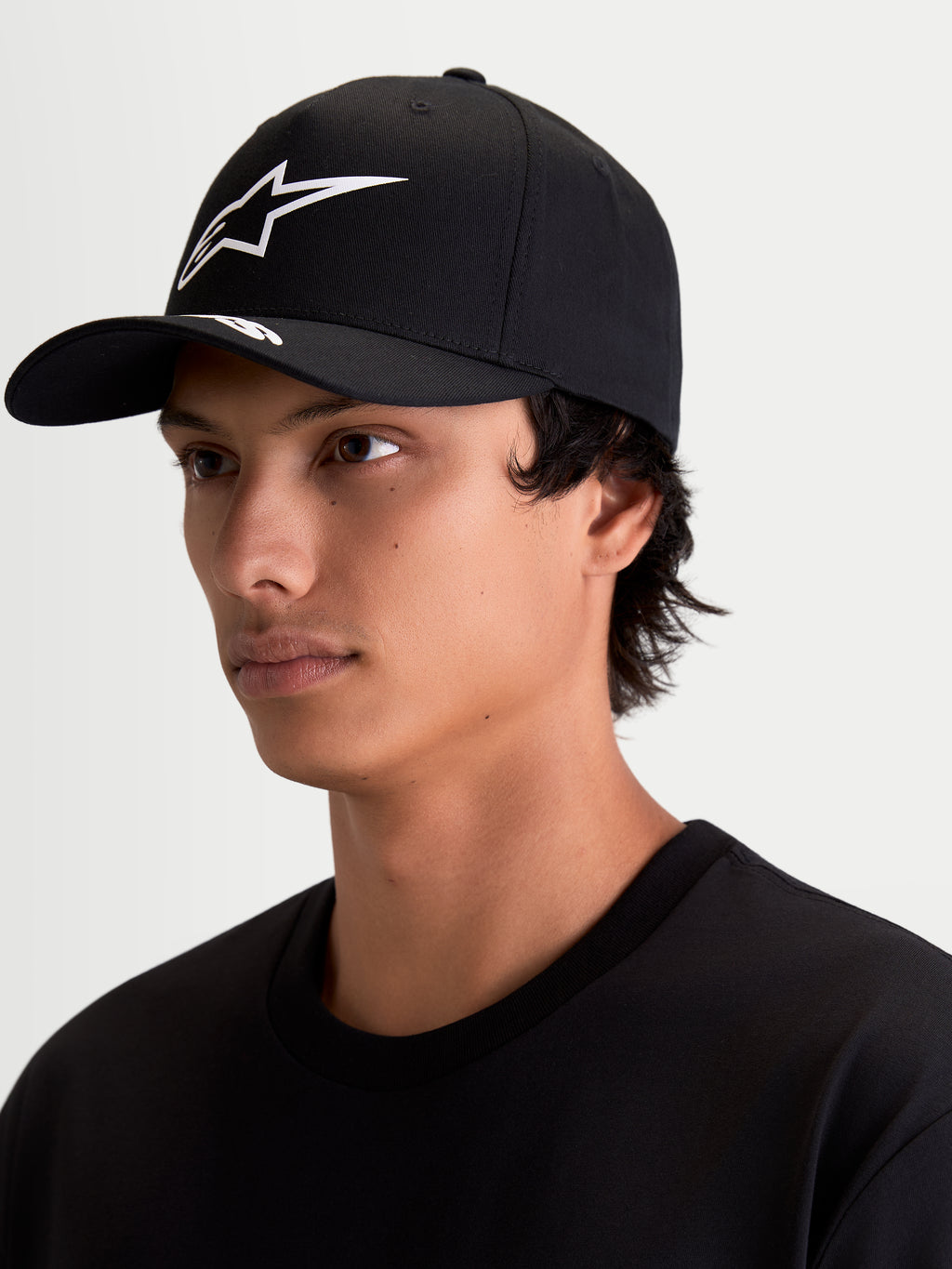 Alpinestars Arclight Kappe, Sportswear Baseballkappe für Herren und Damen, Schwarz und Weiß, mit gebogenem Schirm, strukturierter Krone und weißem strukturiertem Astars Puff-Print-Logo, Twill-Material, am Modell getragen.