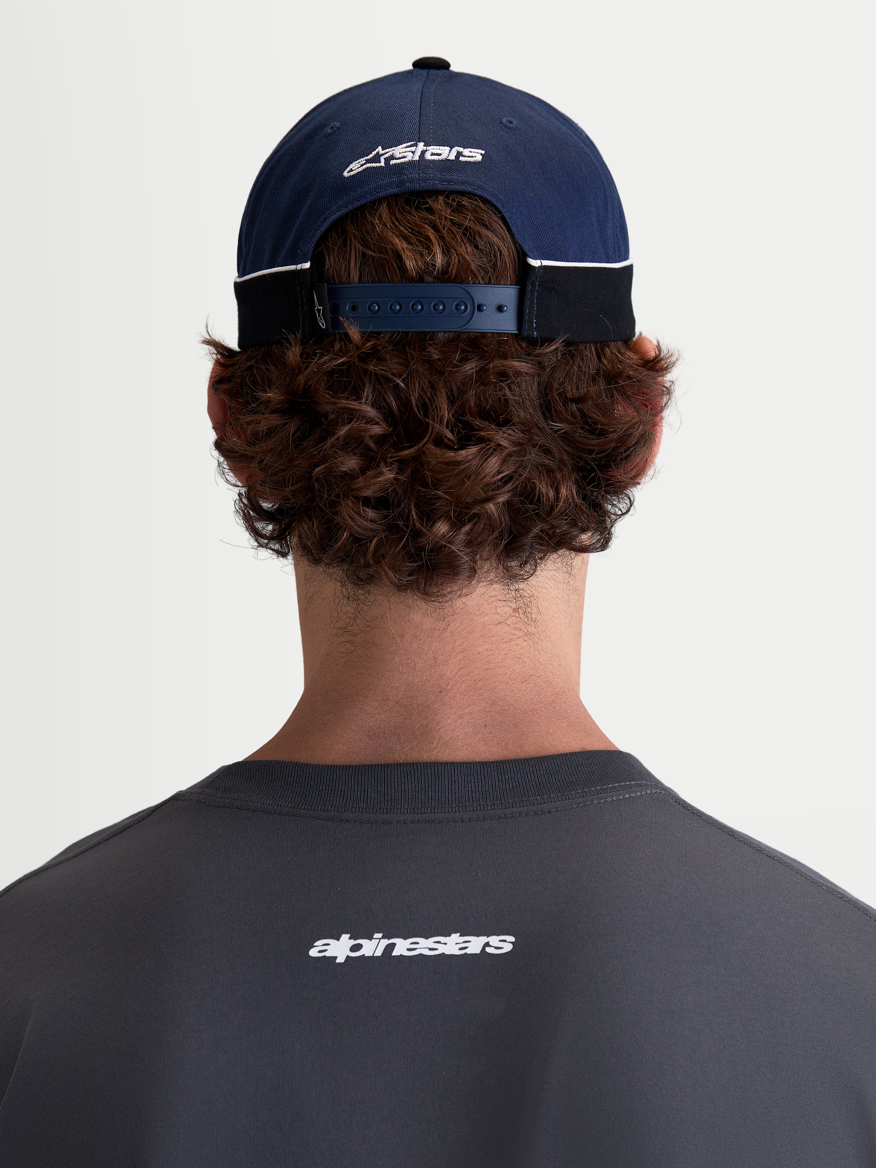 Alpinestars 500 Snapback Kappe, Motorsport-Sportswear-Baseballkappe, Navyblau und Schwarz, 100 % Baumwolltwill-Konstruktion mit verstellbarem Snapback-Verschluss und gesticktem Astars-Logo, Rückansicht am Modell.