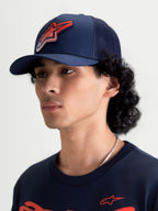Alpinestars Meteorite Trucker-Kappe, Sportswear Mesh-Kappe in Navy-Blau mit rotem Astars Gravel-Texture-Logo, gebogener Schirm und strukturierte Krone, Ansicht am Modell.