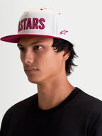 Alpinestars Stadium Snapback Kappe, Sportswear Lifestyle Kappe, Weiß und Rot, flacher Schirm, strukturierte Krone, Astars-Logo-Applikation mit Kontraststich und seitlicher Stickerei, Ansicht am Model.