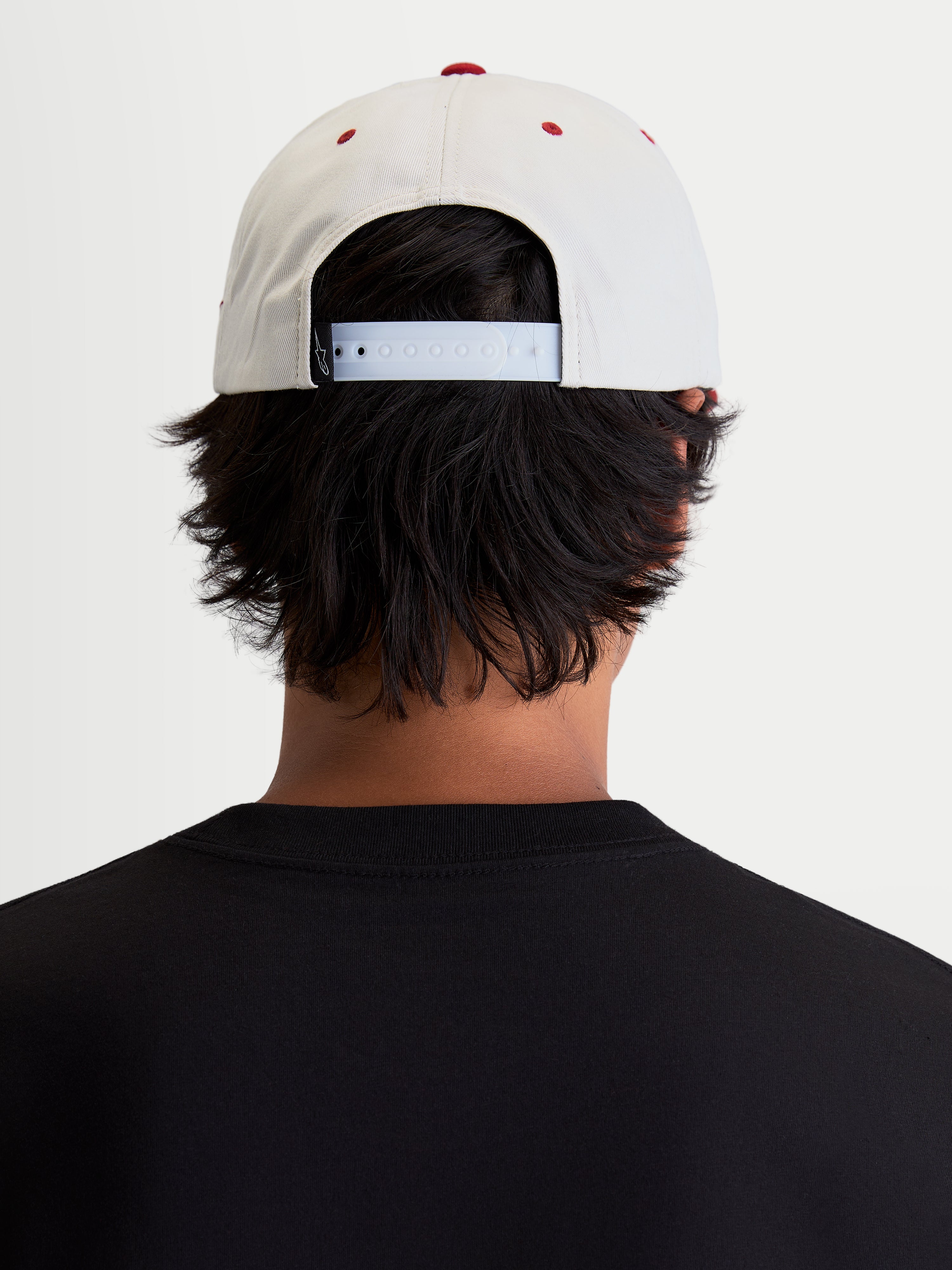 Alpinestars Stadium Snapback Kappe, Sportswear-Freizeitkappe, Off-White und Rot, verstellbarer Snapback-Verschluss und strukturierte Krone, Rückansicht am Model zeigt die Passform für den Motorsport-inspirierten Lifestyle.