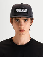 Alpinestars Ten Trucker Hat, flat bill sportswear cap in dark gray, worn by a model, featuring a structured crown and front Alpinestars word logo embroidery patch