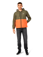 Alpinestars Speeder Windbreaker-Jacke, Color-Block-Design in Military-Grün und Orange, leichte Kapuzenjacke mit schwarzen Kordelzügen und Frontreißverschluss, weißes Logo auf Brust und Ärmel, getragen mit dunklen Jeans und schwarzen Sneakern, lässiger Sportbekleidungs-Stil