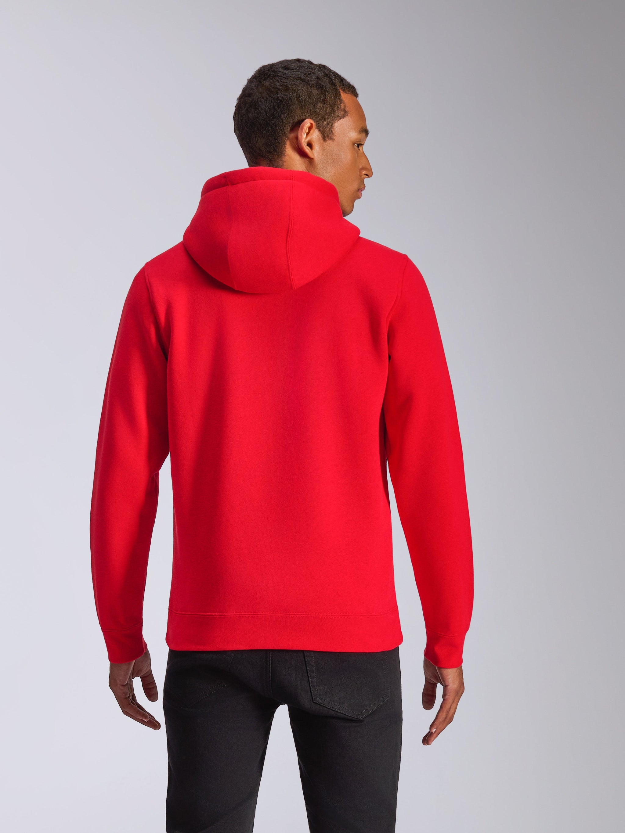 Alpinestars Ageless V3 Hoodie, Rückansicht, roter Kapuzenpullover, lässige Sportbekleidung mit jerseygefütterter Kapuze und Rippbündchen, getragen von einem Model mit schwarzer Hose