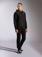 Alpinestars Sessions V3 Hoodie, Kapuzenjacke mit Front-Reißverschluss aus Polyfleece, Schwarz und Grau, graue Logos auf Brust und Ärmeln, Kapuze mit Kordelzug und roten Kordelenden, Ganzkörperansicht eines Models in lässiger Motorsport-Streetwear
