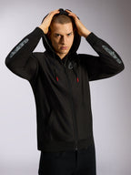 Alpinestars Sessions V3 Hoodie, schwarze Kapuzenjacke mit Reißverschluss, graues Astars-Branding auf den Unterarmen, netzgefütterte Kapuze mit Kordelzügen mit roten Enden, lässige motorsport-inspirierte Streetwear