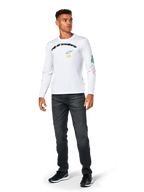 Alpinestars Brundo CSF Langarmshirt, Weiß, lässige Sportbekleidung, mit schwarzem 'alpinestars' Brust-Schriftzug, blauem Stern-Logo und gelben 'AS' Initialen, bunte Grafiken am Ärmel, kombiniert mit dunkler Jeans und schwarzen Sneakern
