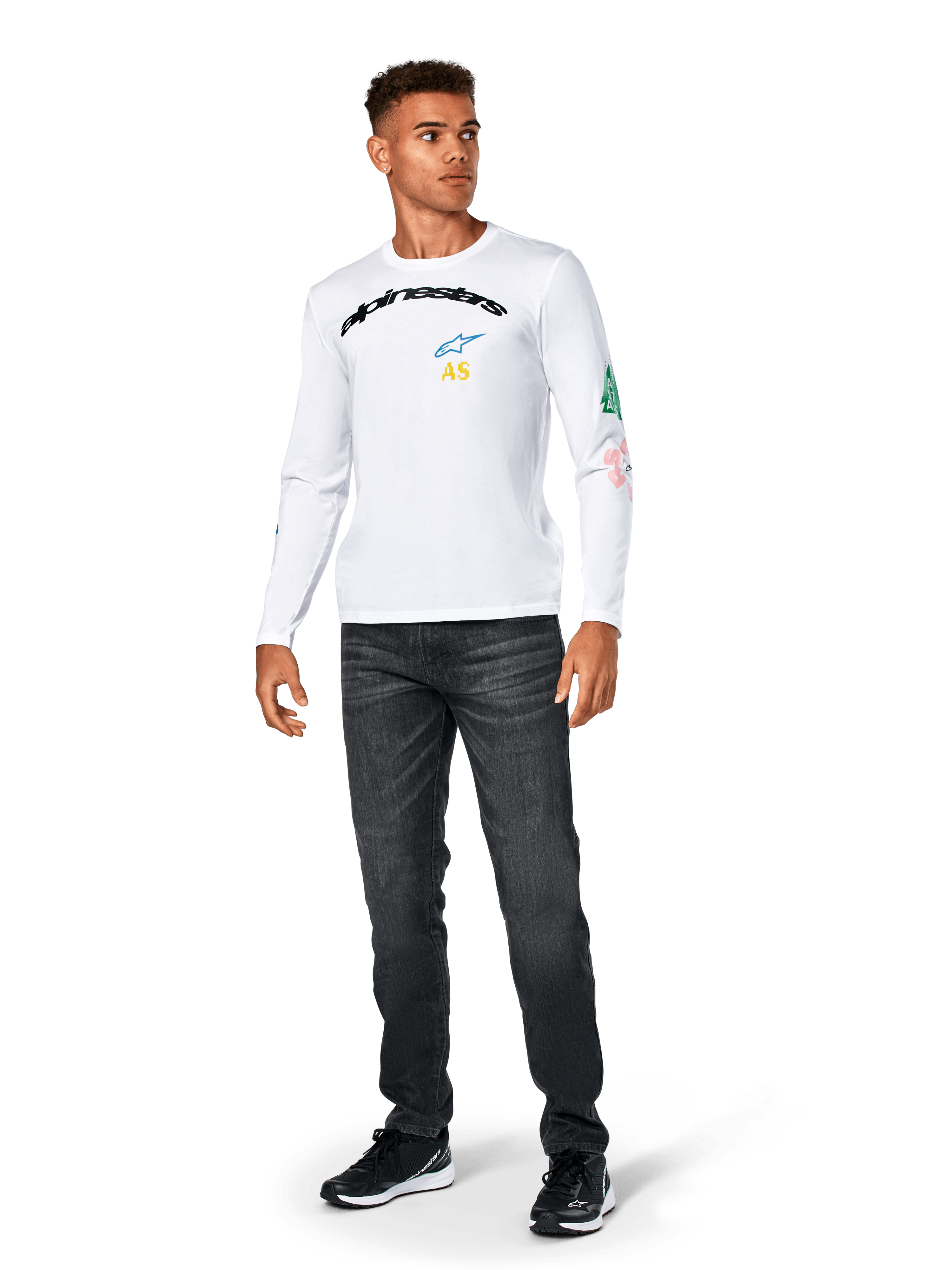 Alpinestars Brundo CSF Langarmshirt, Weiß, lässige Sportbekleidung, mit schwarzem 'alpinestars' Brust-Schriftzug, blauem Stern-Logo und gelben 'AS' Initialen, bunte Grafiken am Ärmel, kombiniert mit dunkler Jeans und schwarzen Sneakern