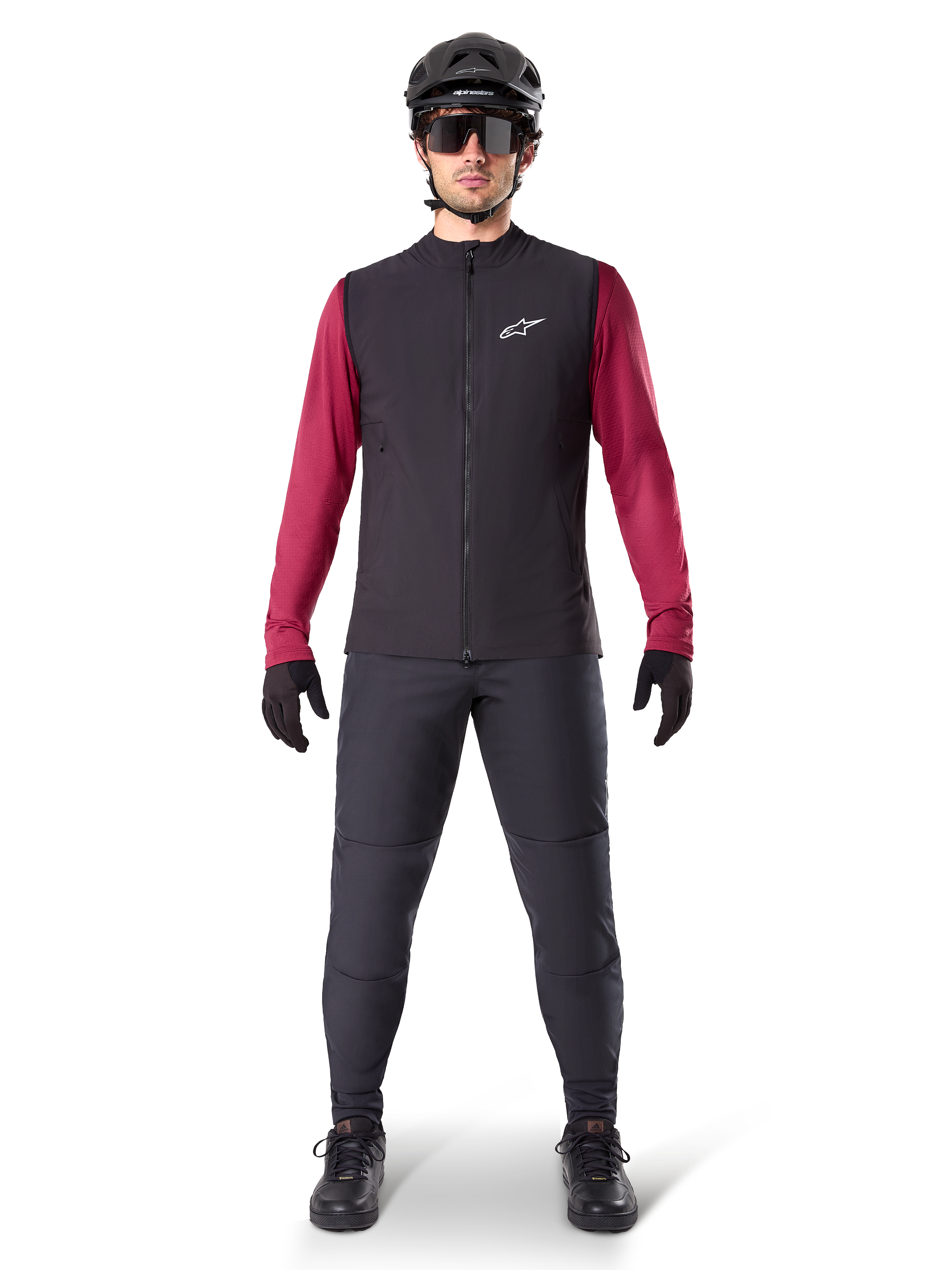 Alpinestars A-Dura Thermal Vest, Black cycling gilet worn over a maroon long-sleeve jersey, paired with dark grey MTB pants, black helmet and sunglasses, technical mountain bike apparel for cold-weather riding