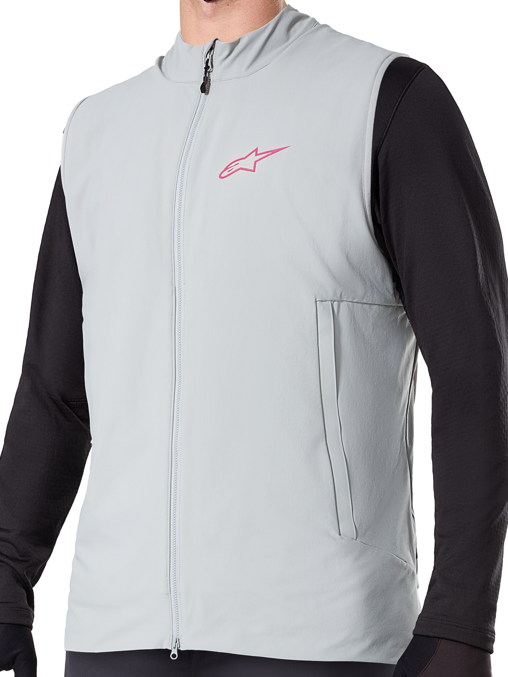 Alpinestars A-Dura Thermoweste, isolierte Fahrradweste in Titanium Grau, mit pinkem Stern-Logo auf der Brust, getragen über einem schwarzen langärmeligen Oberteil, inklusive vertikaler Reißverschlusstasche und durchgehendem Frontreißverschluss, entwickelt für Mountainbike-Touren bei kaltem Wetter.