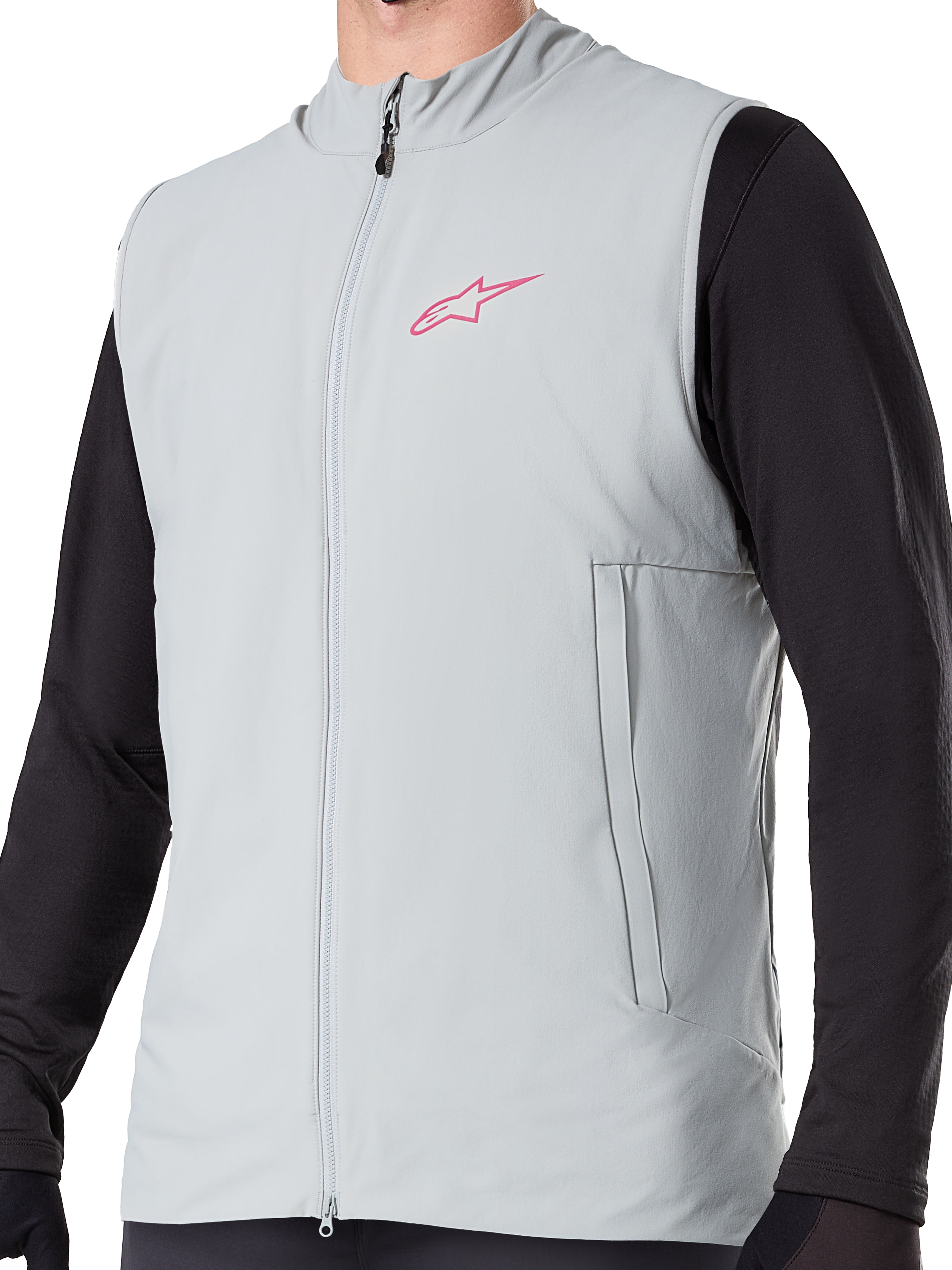 Alpinestars A-Dura Thermoweste, isolierte Fahrradweste in Titanium Grau, mit pinkem Stern-Logo auf der Brust, getragen über einem schwarzen langärmeligen Oberteil, inklusive vertikaler Reißverschlusstasche und durchgehendem Frontreißverschluss, entwickelt für Mountainbike-Touren bei kaltem Wetter.