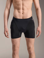 Alpinestars A-Motion Plasma Protektoren-Boxershorts, MTB-Protektorenshorts, Schwarz mit Black Camo-Akzenten, Frontansicht an männlichem Model, mit atmungsaktivem Stretch-Mesh und integriertem Hüftschutz für Radsport-Performance.