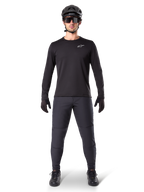 Alpinestars A-Dura Thermal Pant, Black, worn by a rider in complete mountain bike gear including a black long-sleeve jersey, helmet, and sunglasses, durable pants with a regular fit for cold-weather trail riding
