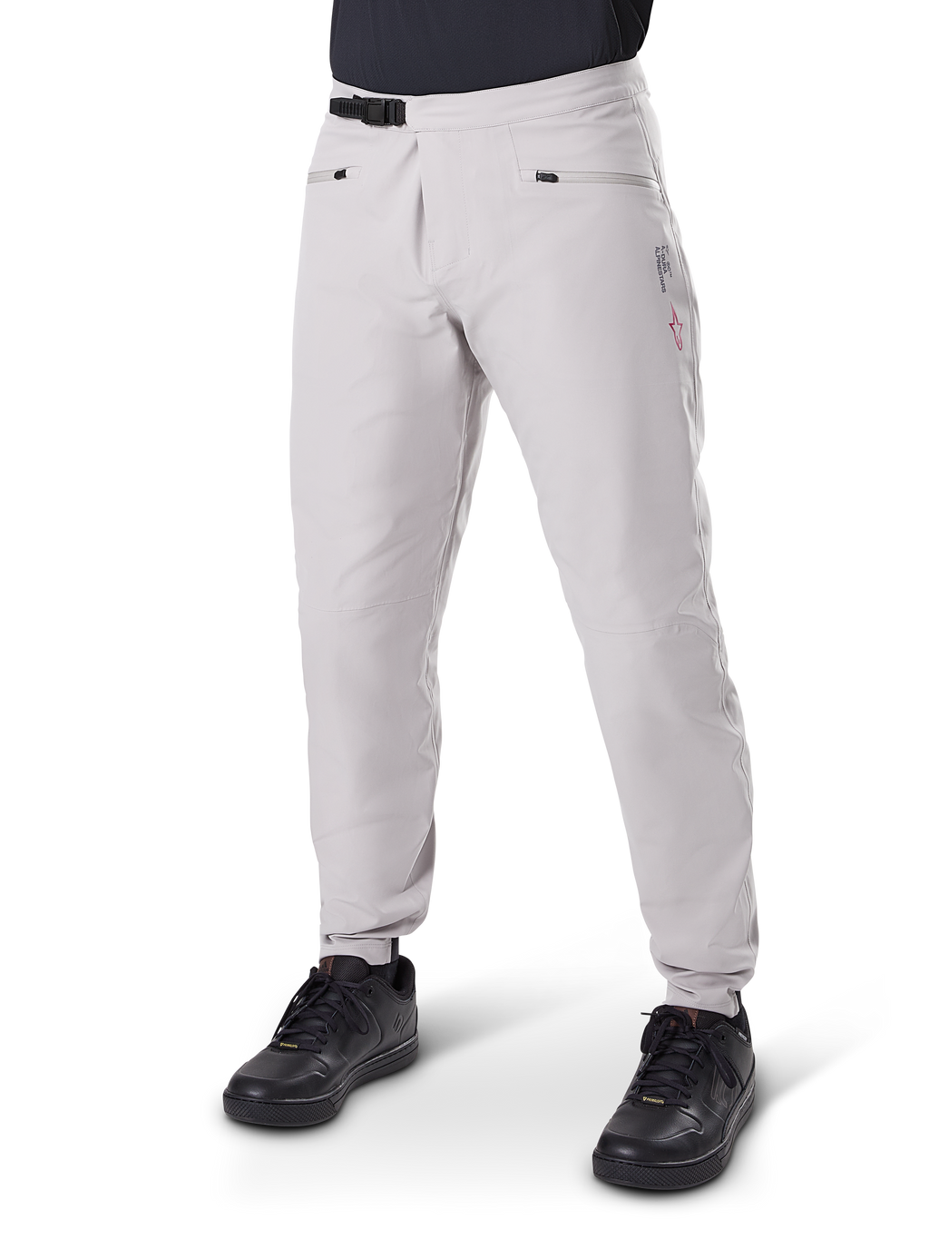 Alpinestars A-Dura wasserdichte Hose, Mountainbike-Hose, Titanium Grau, mit schwarzem Ratschenverschluss an der Taille und Reißverschlusstaschen, konisch zulaufende Beine mit elastischen Bündchen, getragen mit schwarzen Schuhen, strapazierfähige wasserdichte 3L-Konstruktion für den Offroad-Radsport