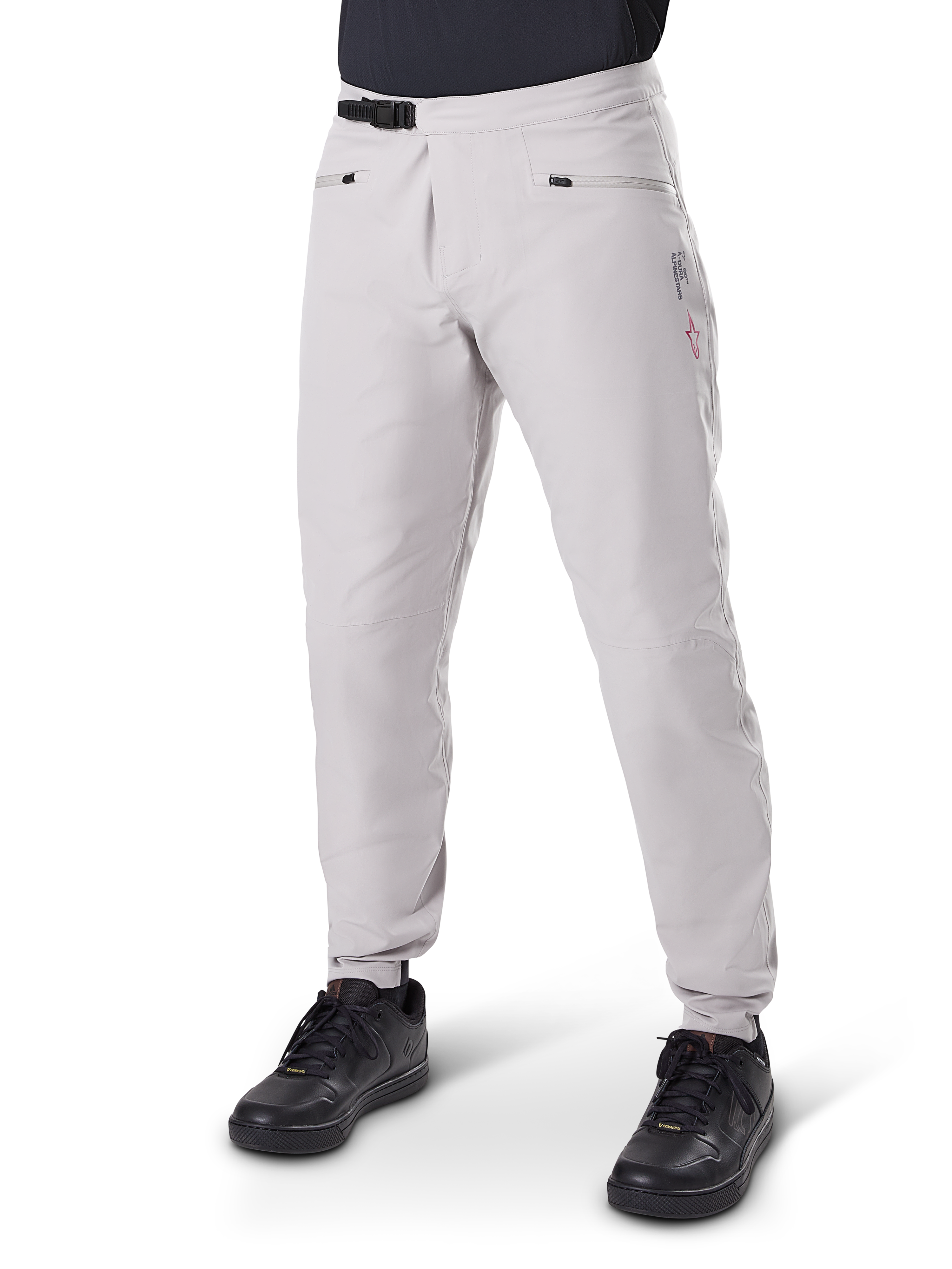 Alpinestars A-Dura wasserdichte Hose, Mountainbike-Hose, Titanium Grau, mit schwarzem Ratschenverschluss an der Taille und Reißverschlusstaschen, konisch zulaufende Beine mit elastischen Bündchen, getragen mit schwarzen Schuhen, strapazierfähige wasserdichte 3L-Konstruktion für den Offroad-Radsport