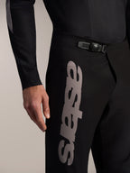 Schwarze Alpinestars A-Supra Elite MTB-Hose mit Ratschenverschluss und markantem grauen Astars-Logo am Oberschenkel.