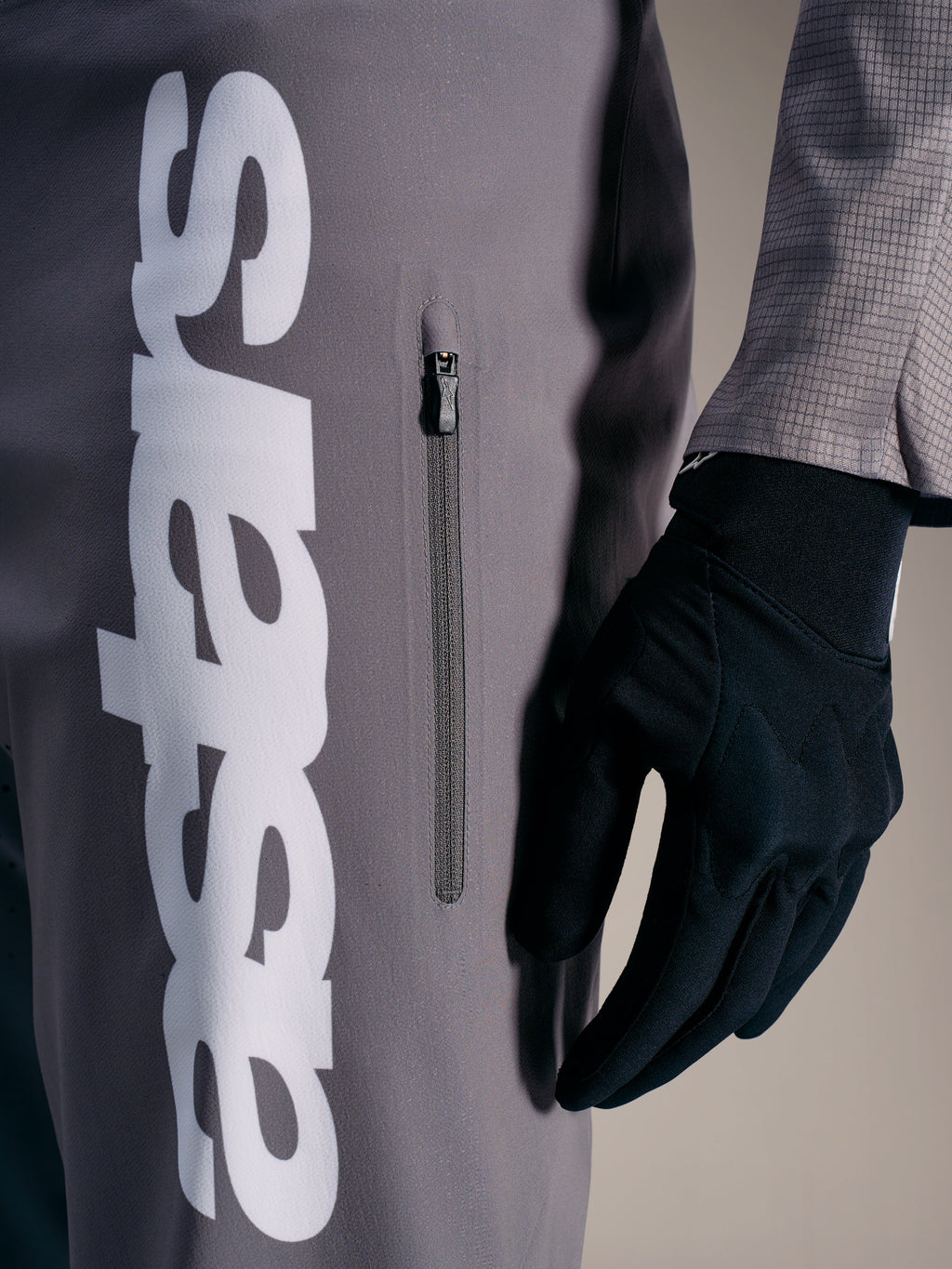 A-Supra Elite Hose in Faded Gray mit markantem weißem Logo und vertikaler Reißverschlusstasche für MTB-Rennen.