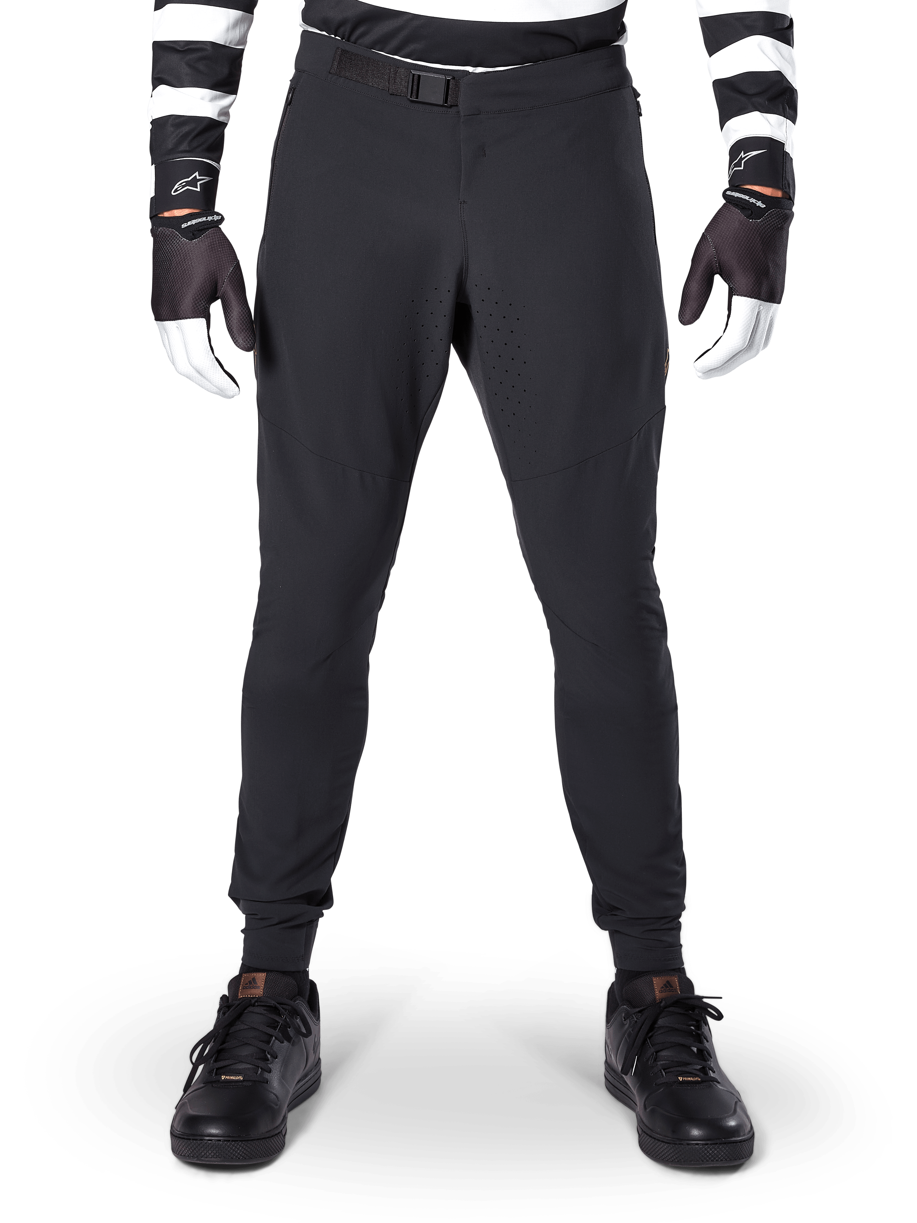 Alpinestars A-Aria Elite Pants, Mountain Bike Pants, Black, front view showing laser perforations and magnetic buckle closure, worn with a black and white striped jersey and black gloves, performance cycling gear for trail riding