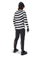 Alpinestars A-Aria Elite Pants, Black MTB Pants, featuring gold vertical logo on the calves, worn by a rider with a black and white striped long-sleeve jersey, black helmet, and black shoes, rear view showing performance fit and trail-ready design