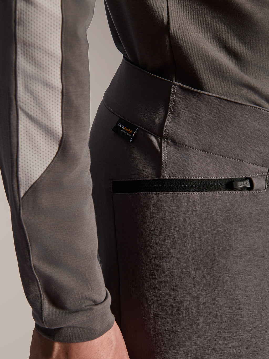 Alpinestars A-Dura Elite Pants, Dark Gray mountain bike pants, close-up detail of zippered side pocket and Cordura fabric tag, durable 4-way stretch textile for off-road performance
