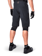 Rear view of a rider wearing Alpinestars A-Aria Elite Shorts in Black, performance mountain bike shorts, styled with black cycling gloves and black shoes, designed for flexible movement on off-road trails