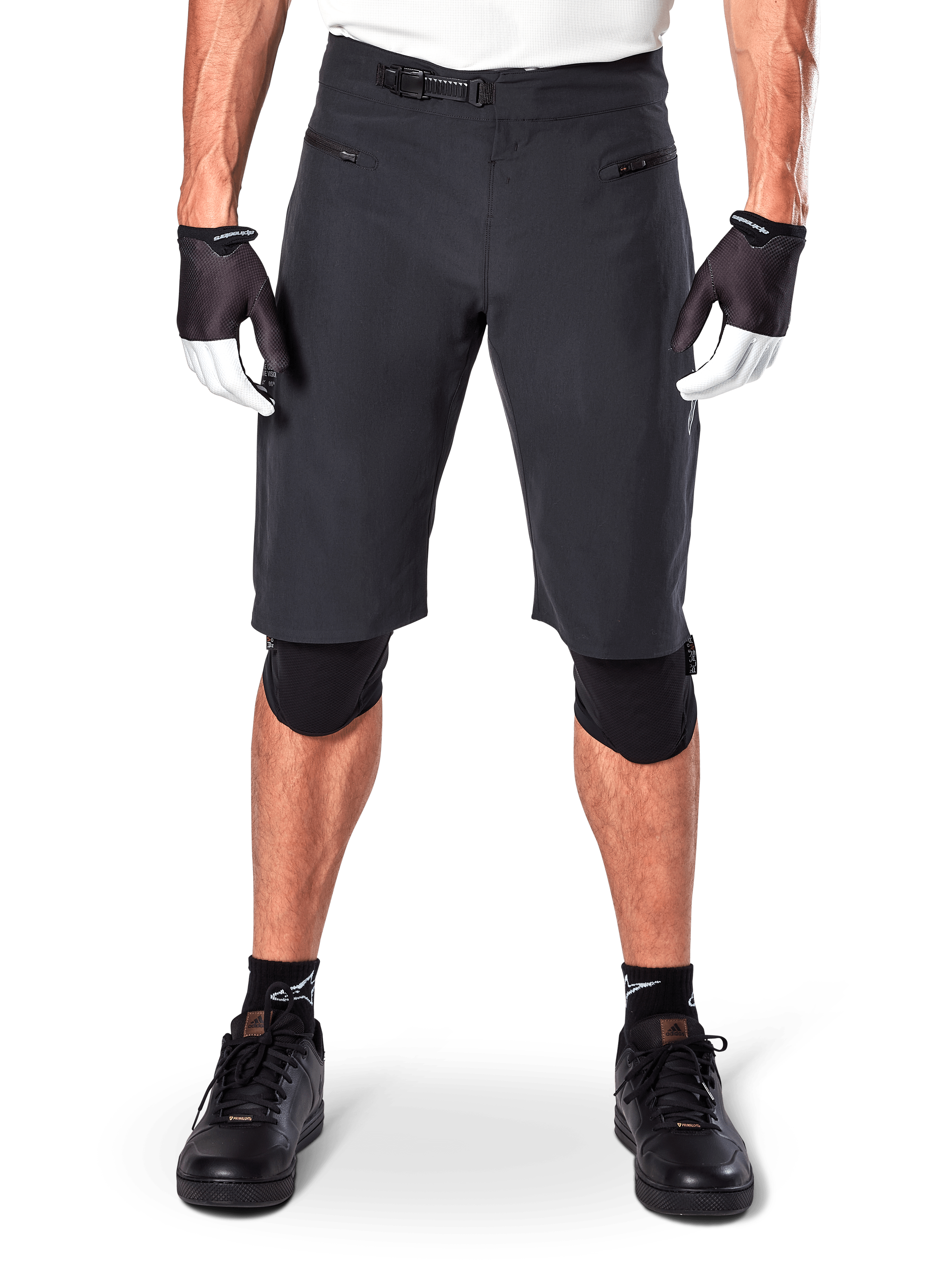 Alpinestars A-Aria Shorts, Black Mountain Bike Shorts, featuring a ratchet waist closure and zippered pockets, worn with black and white gloves and knee pads, technical cycling gear for off-road riding