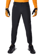 Alpinestars A-Dura Pants, Mountain Bike Pants, Black, worn with an orange long-sleeve jersey and black and orange gloves, featuring a double snap closure and side waist adjusters, durable textile for off-road cycling