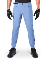Alpinestars A-Dura Pants, MTB Pants, Infinity Blue, light blue mountain bike trousers featuring double snap closure and zippered pockets, worn with black gloves and black shoes, regular fit with elasticated cuffs
