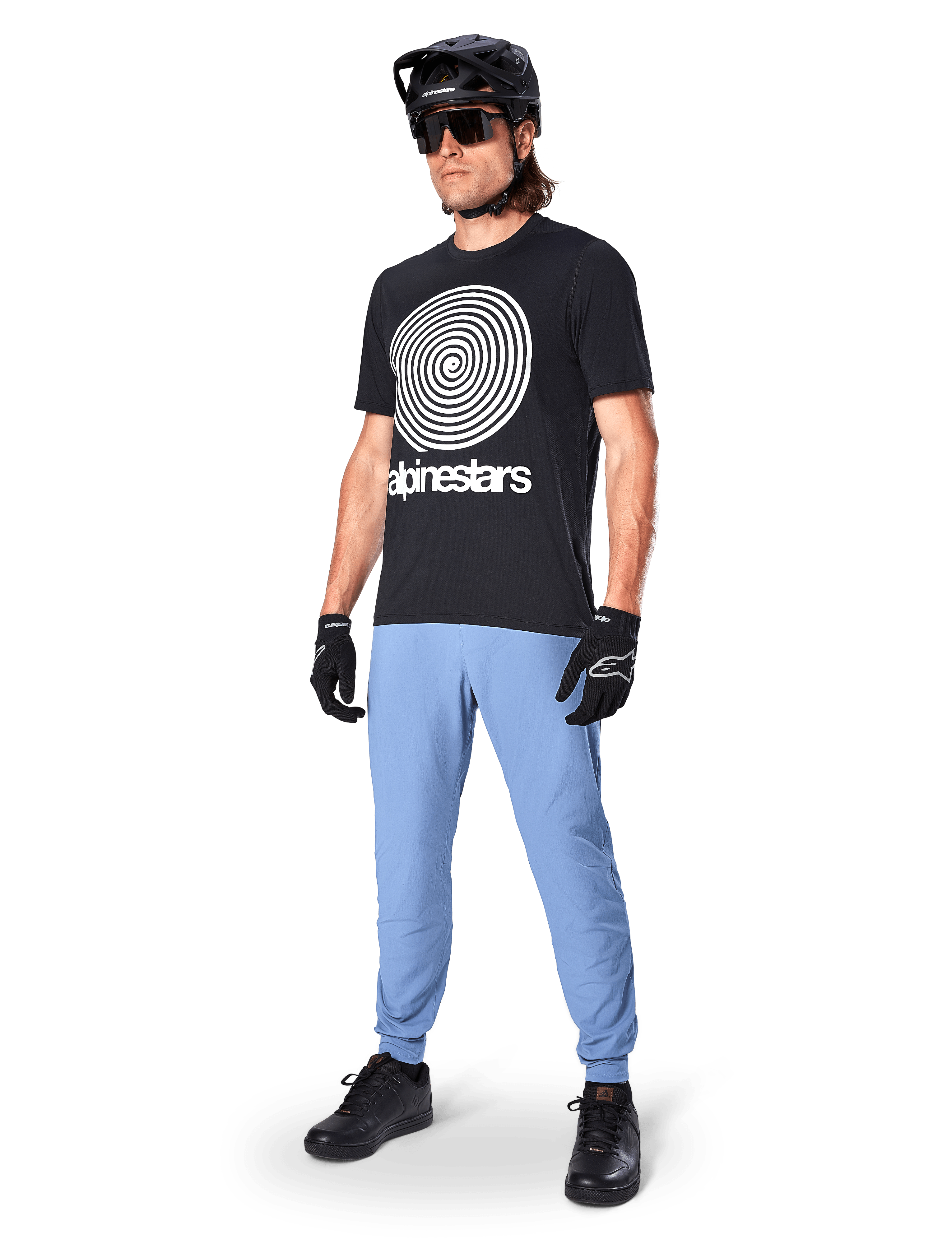 Alpinestars A-Dura Pants, MTB Pants, Infinity Blue, worn with black graphic t-shirt featuring white spiral logo, black helmet, sunglasses, and black gloves, professional mountain bike gear
