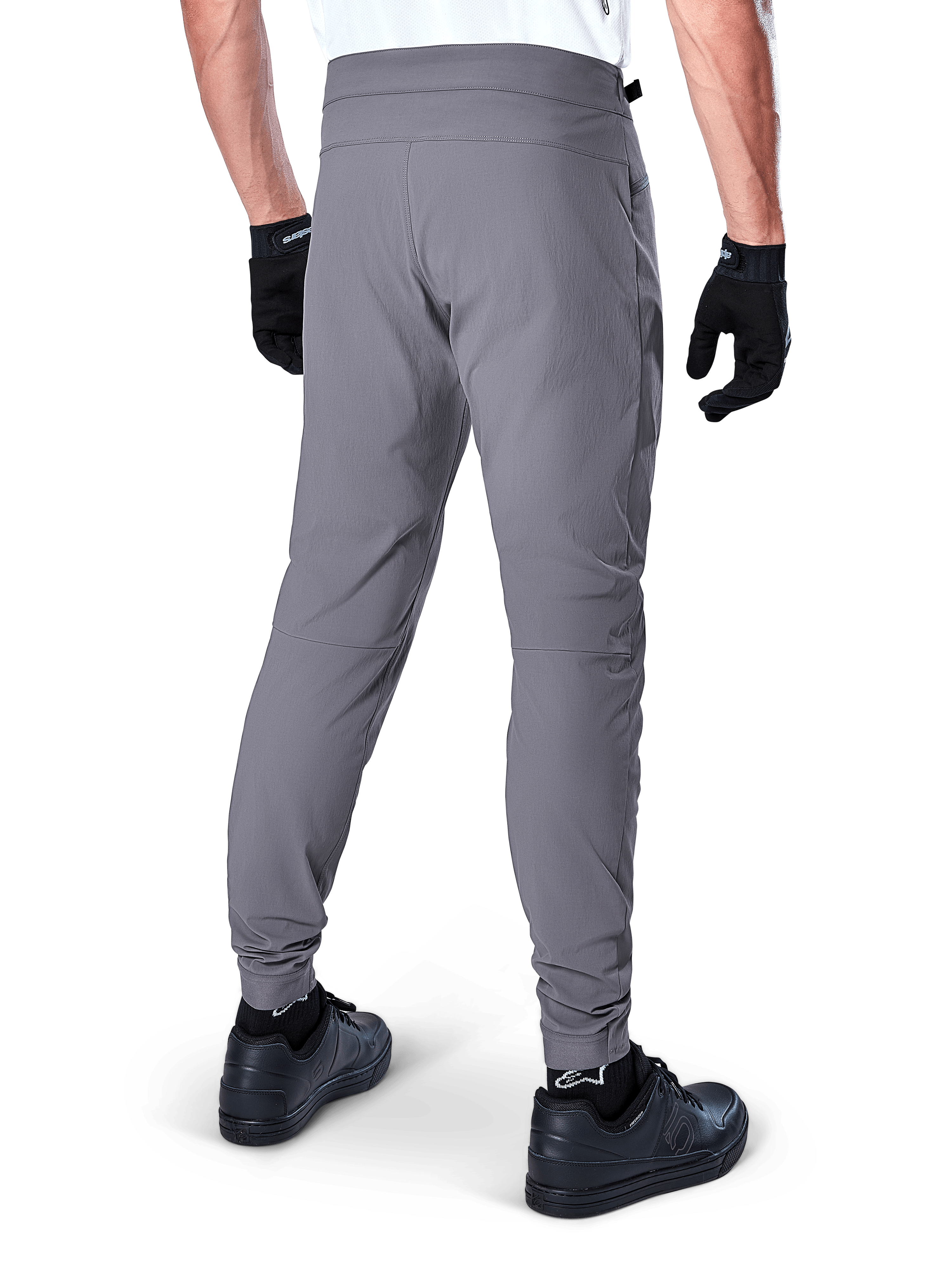 Alpinestars A-Dura Pants, Mountain Bike Pants, Dark Gray, rear view of model wearing the gear, featuring a durable 2-way stretch fabric and elasticated cuffs, coordinated with black gloves and sneakers for a cycling-ready look
