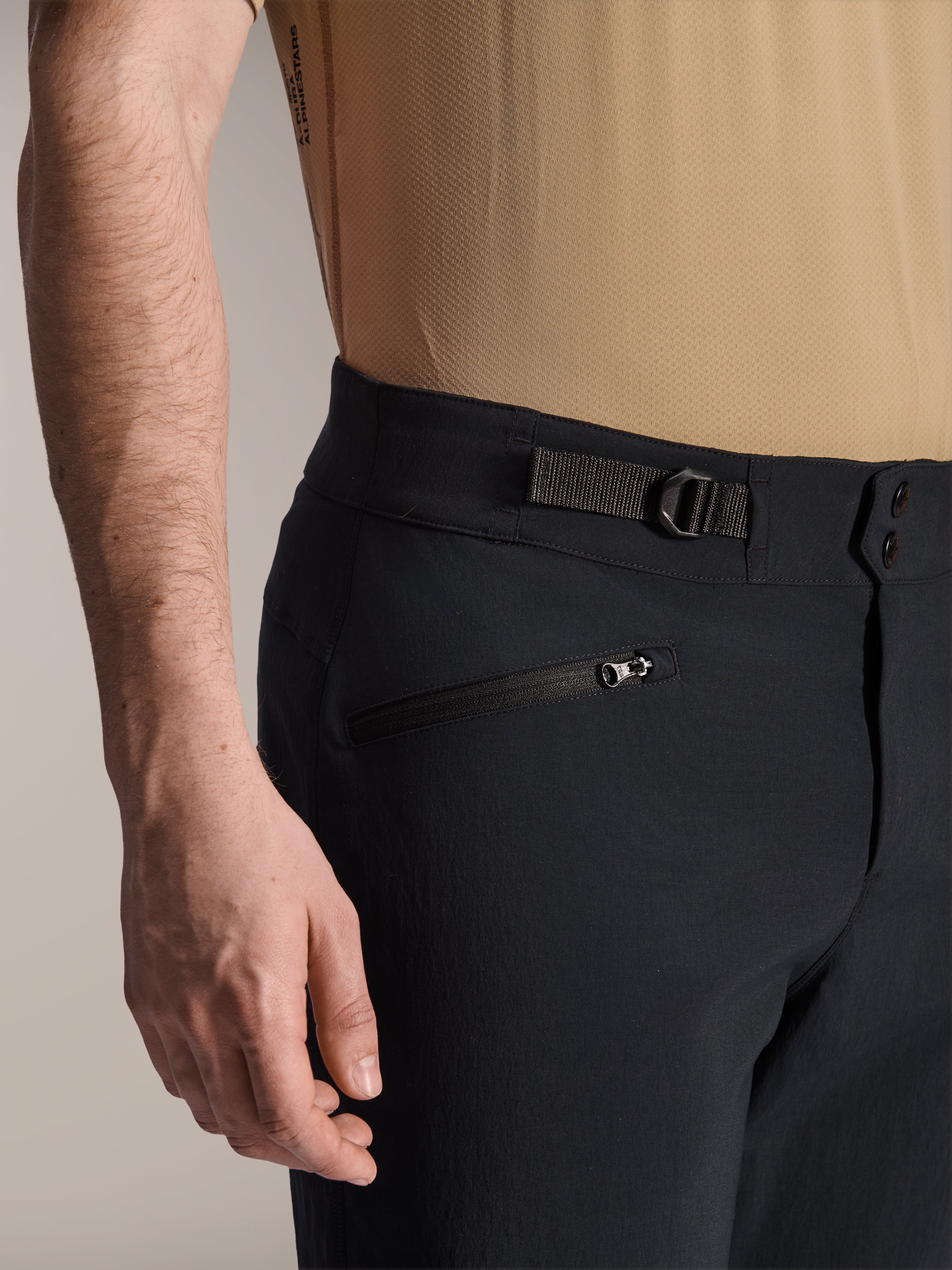 Alpinestars A-Dura Shorts, Black MTB shorts, close-up view showing zippered pocket and adjustable side cinch strap, double snap closure, durable fabric for mountain biking