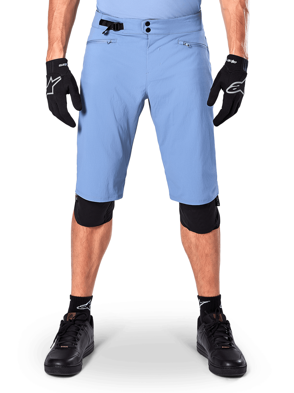 Alpinestars A-Dura Shorts, Mountainbike-Shorts in Infinity Blue, getragen mit schwarzen Handschuhen und Knieschonern, mit doppeltem Druckknopfverschluss und seitlichem Taillenversteller, Performance-MTB-Ausrüstung