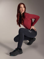 Alpinestars Stella A-Dura Thermohose, MTB-Hose für Damen, Schwarz, getragen von einem Modell in hockender Pose mit einem weinroten Langarmshirt und schwarzen Radschuhen, mit weißem Stern-Logo auf dem Oberschenkel, strapazierfähige und warme Konstruktion für Geländefahrten bei kaltem Wetter