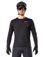 Alpinestars A-Dura Thermal Jersey, Black long-sleeve mountain bike jersey, worn with a black helmet and large sunglasses, featuring a small white Alpinestars logo on the chest, regular fit, MTB cycling apparel