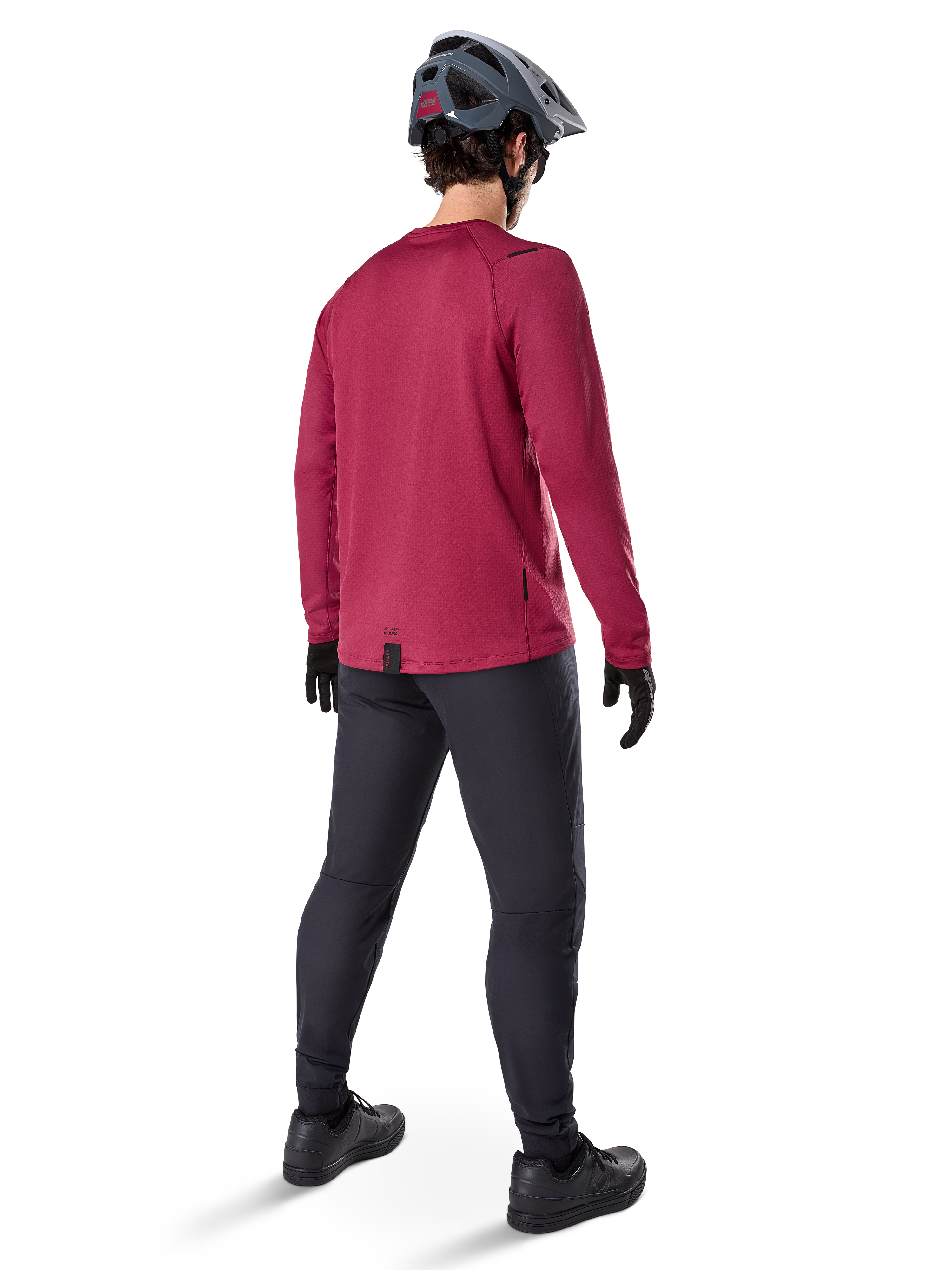 Alpinestars A-Dura Thermal Jersey, langärmeliges Radsport-Trikot in Burgunderrot, Rückansicht, getragen mit einer schwarzen Mountainbike-Hose und einem grauen Helm, mit verlängertem Rückenteil für zusätzlichen Schutz, Mountainbike-Ausrüstung für kaltes Wetter