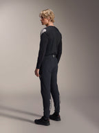 Alpinestars A-Aria Polartec Elite Langarm-Trikot, Schwarz, getragen von einem Modell in der Rückansicht im Profil, mit weißem Logo auf der Schulter, kombiniert mit einer passenden schwarzen Radhose für ein professionelles MTB-Outfit.