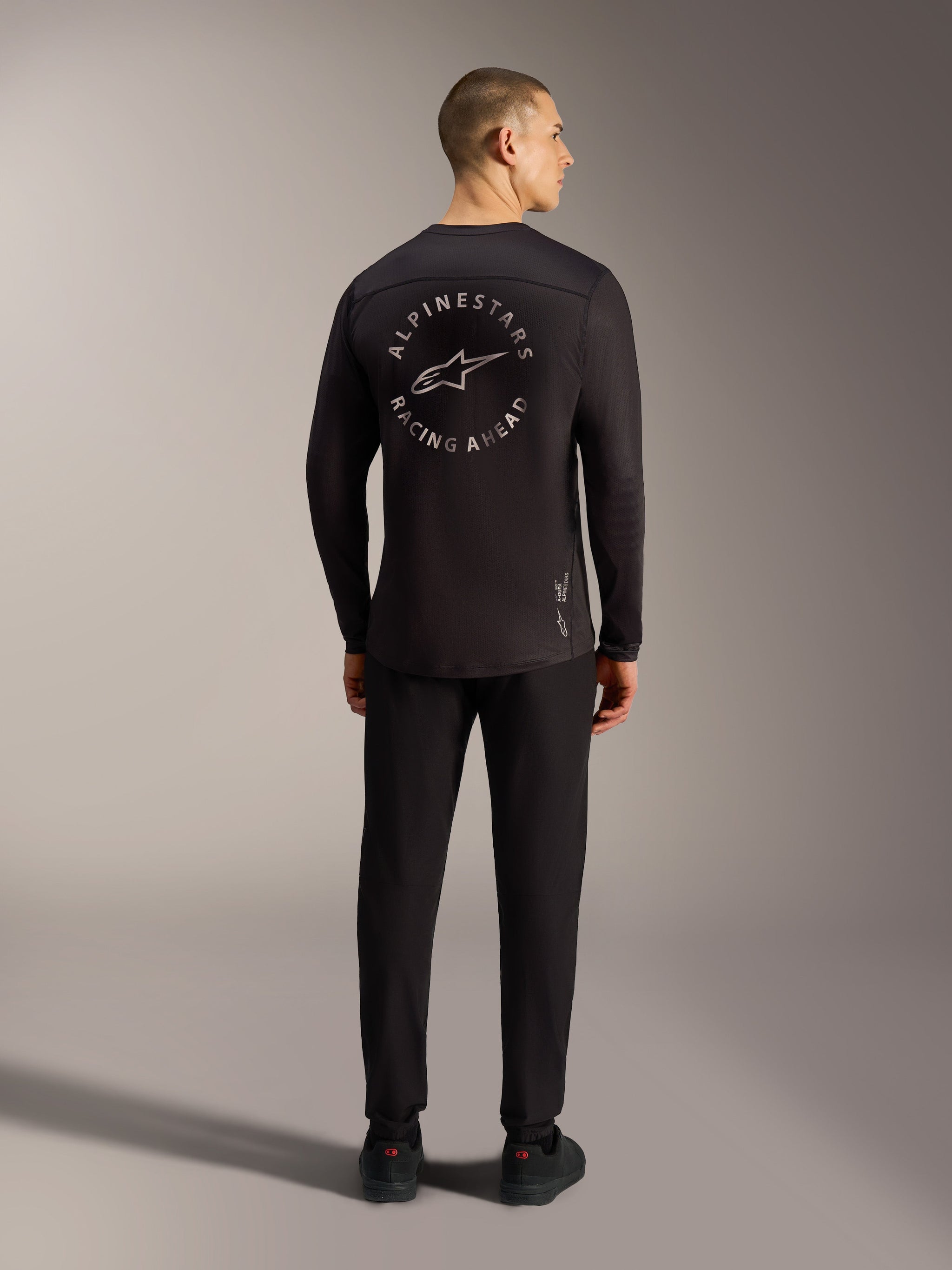 Black A-Dura Air Long Sleeve Jersey featuring a Racing Ahead circular back graphic and breathable jacquard mesh for MTB.