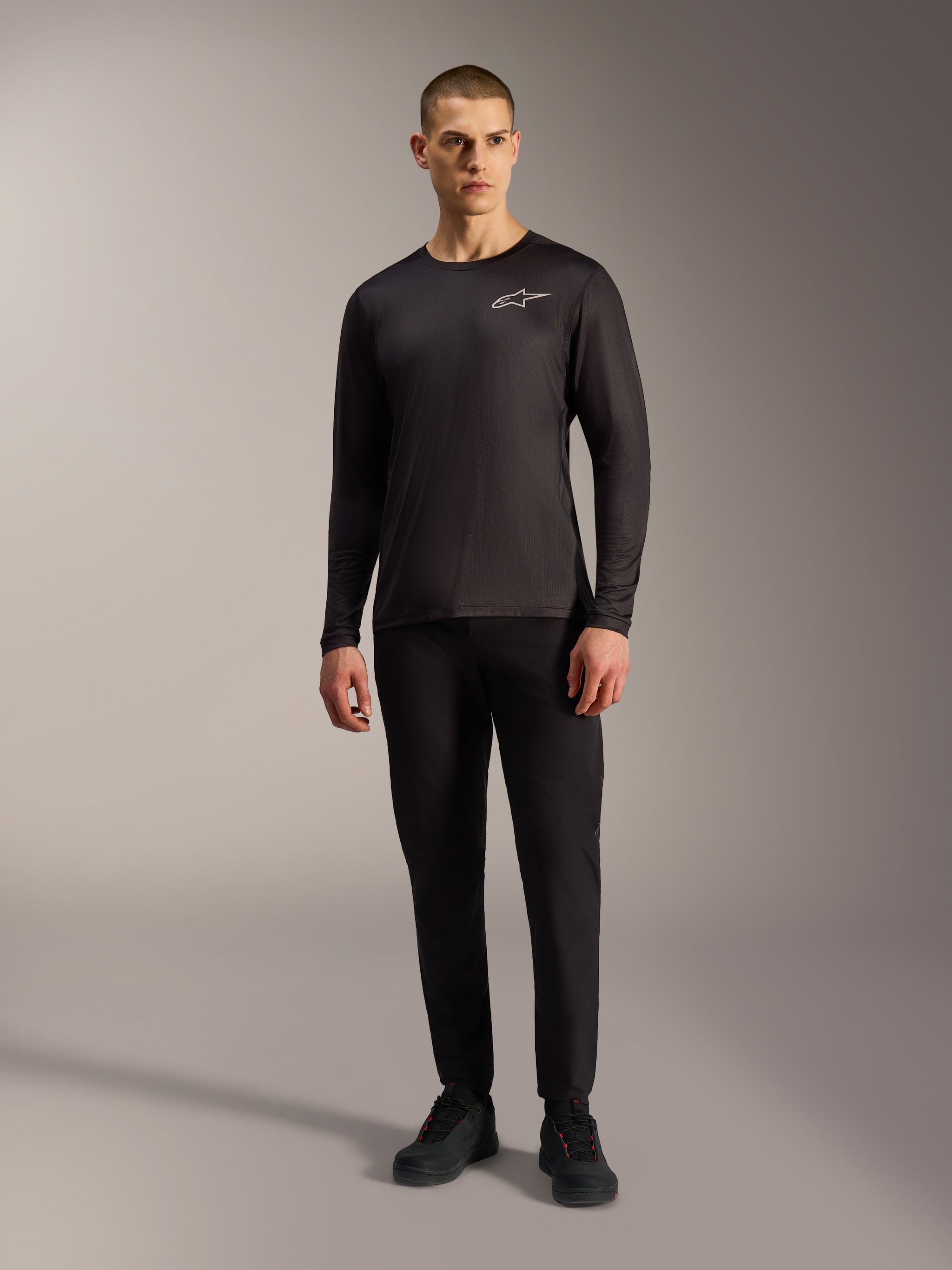 Black A-Dura Air Long Sleeve Jersey, moisture-wicking MTB apparel with white Alpinestars logo on a male model.